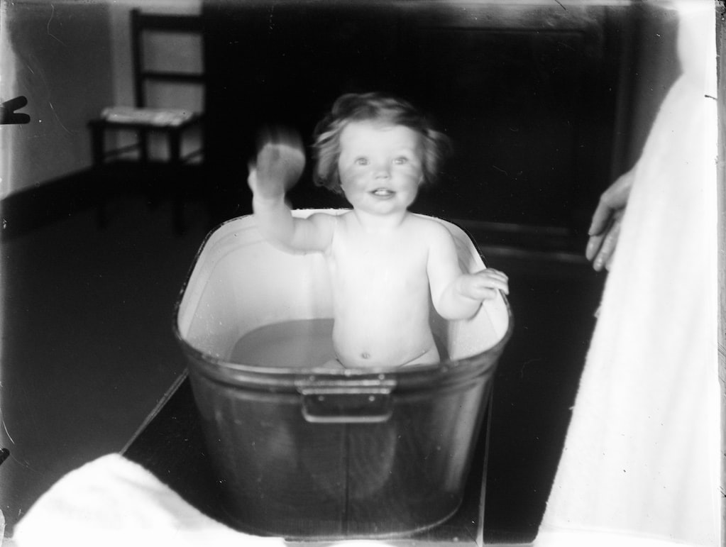 Old image of a waving child in a bathtub